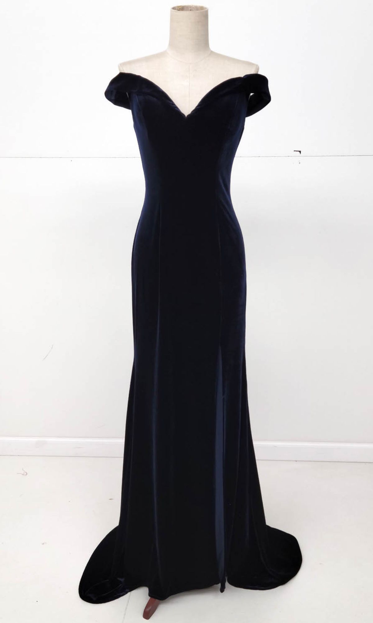 The Off-the-Shoulder Long Prom Dress: Chicas C6532 is a black, floor-length velvet gown displayed on a mannequin against a plain white background, ideal as an elegant formal dress.